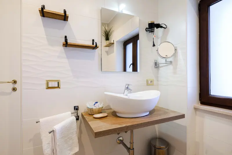 Bathroom with a basin on a wooden shelf