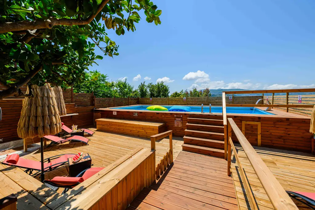 Pool with wooden sun deck and a view of the Cilento hills
