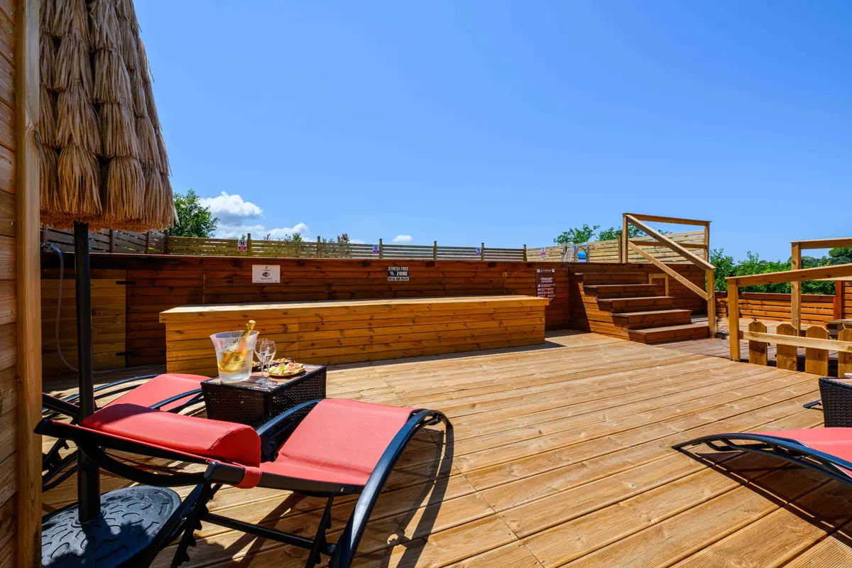 Wooden sun deck with loungers by the pool