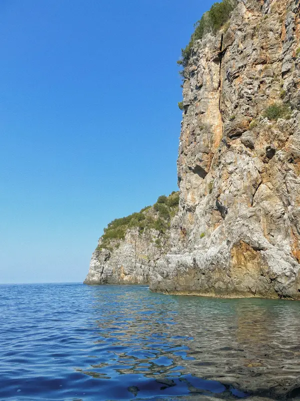 A cliff dropping into the crystal-clear sea of the Cilento